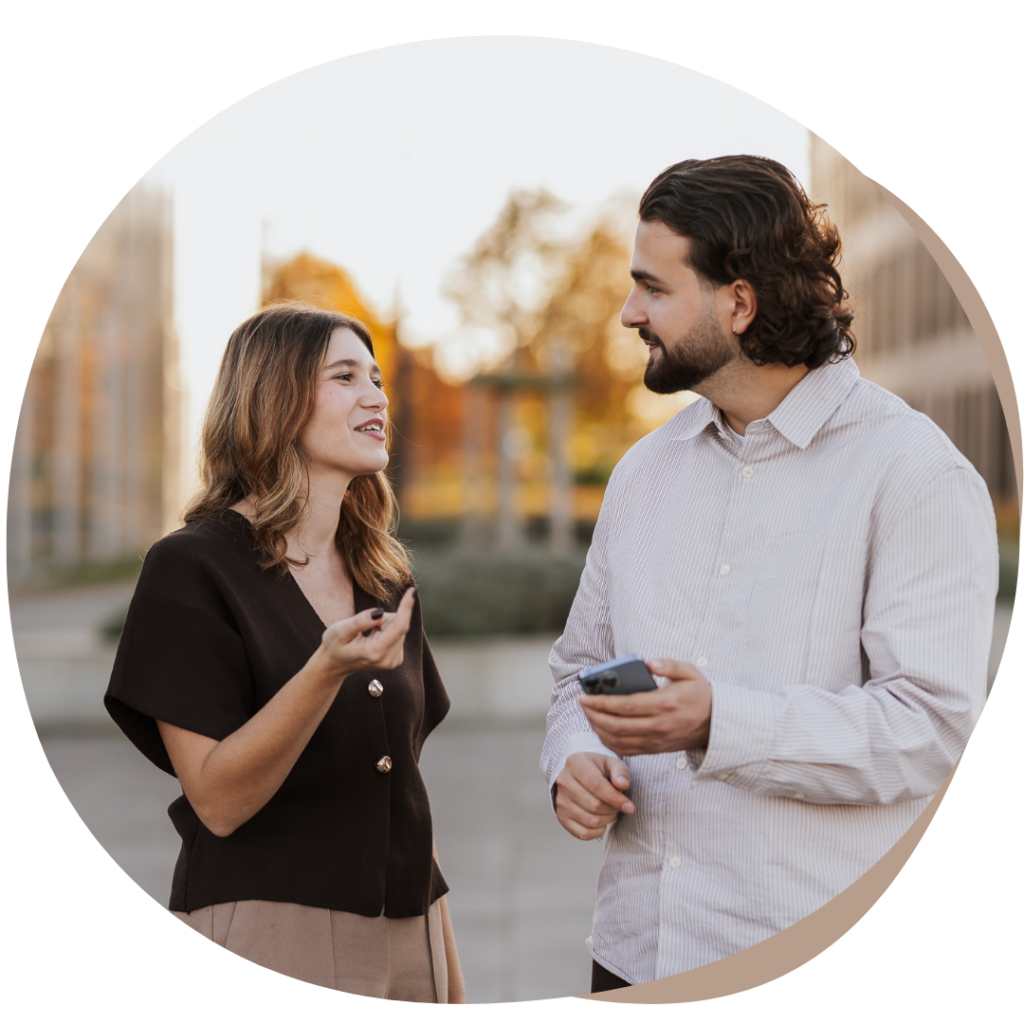 E-Volve Business Stylist Valentino en Lorena praten over social media met een smartphone in de hand